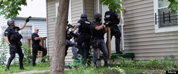 Police from tactical team making entry to serve a high-risk drug related search warrant. Street Narcotics Unit.